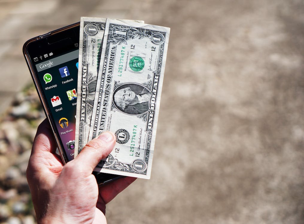 Free Persom Holding Black Android Smartphone and 2 1 U.s. Dollar Stock Photo